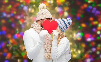 Image showing smiling couple in winter clothes with red heart