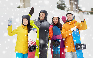 Image showing happy friends in helmets with snowboards