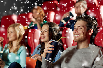 Image showing happy friends with popcorn and drinks in cinema