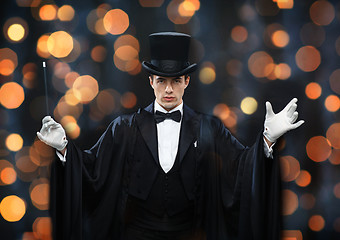 Image showing magician in top hat showing trick with magic wand