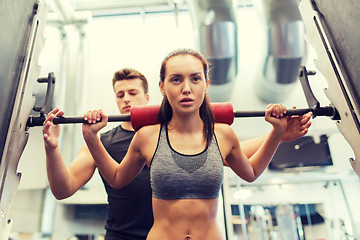 Image showing man and woman with barbell flexing muscles in gym