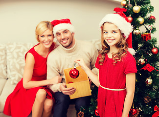Image showing smiling family decorating christmas tree