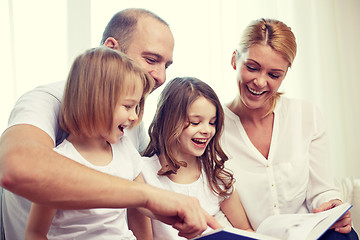 Image showing happy family with book at home