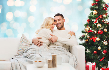 Image showing happy couple hugging on couch at christmas