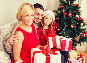 Image showing smiling family holding many gift boxes