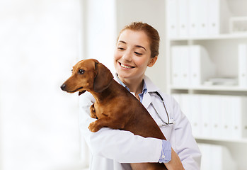 Image showing happy doctor with dog at vet clinic