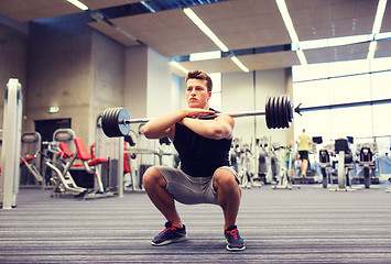 Image showing young man flexing muscles with barbell in gym