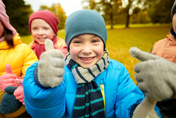 Image showing happy children showing thumbs up in autumn park