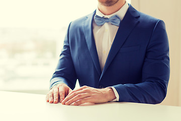 Image showing close up of man in suit and bow-tie at table