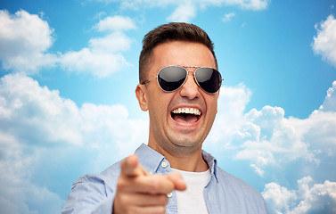 Image showing laughing man in sunglasses pointing finger on you