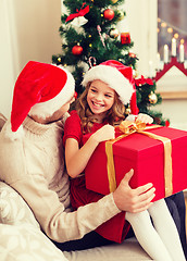 Image showing smiling father and daughter opening gift box