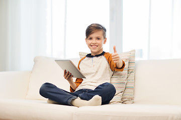 Image showing smiling boy with tablet showing thumbs up at home