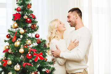 Image showing happy couple hugging near christmas tree at home