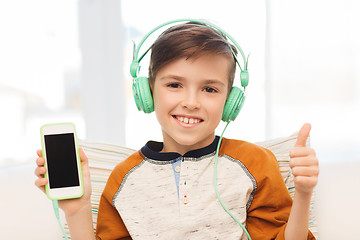 Image showing happy boy with smartphone and headphones at home