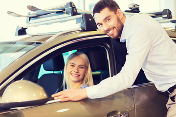 Image showing happy couple buying car in auto show or salon