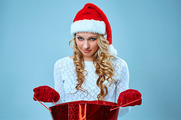 Image showing Frustrated and annoyed beautiful young woman in Santa Claus hat