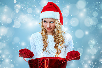 Image showing Frustrated and annoyed beautiful young woman in Santa Claus hat