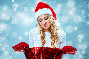 Image showing Frustrated and annoyed beautiful young woman in Santa Claus hat