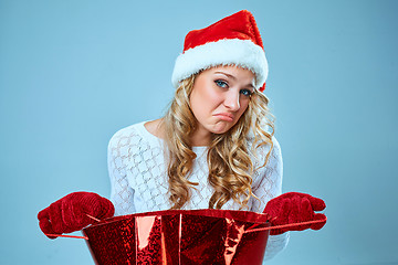 Image showing Frustrated and annoyed beautiful young woman in Santa Claus hat