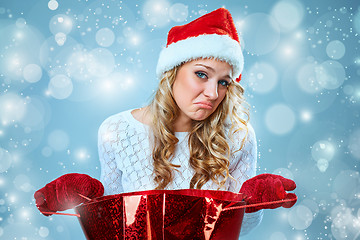 Image showing Frustrated and annoyed beautiful young woman in Santa Claus hat