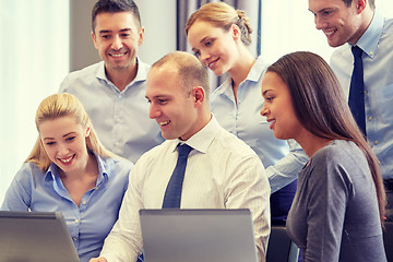 Image showing smiling business people with laptop computer