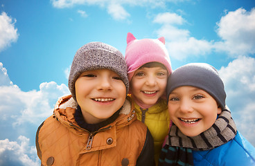 Image showing happy children hugging over blue sky background