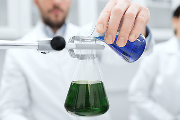 Image showing close up of scientist filling test tubes in lab