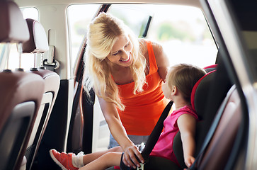 Image showing happy mother fastening child with car seat belt