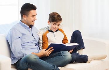 Image showing happy father and son reading book at home