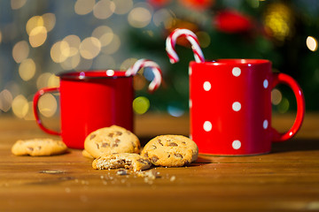 Image showing christmas candy canes and cups on wooden table