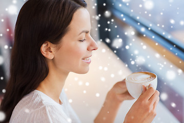 Image showing smiling young woman drinking coffee at cafe