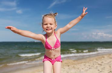 Image showing happy little girl in swimwear having fun on beach