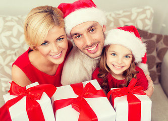 Image showing smiling family holding many gift boxes