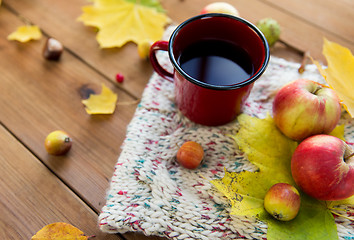 Image showing close up of tea cup on table with autumn leaves