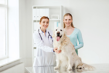 Image showing happy woman with dog and doctor at vet clinic