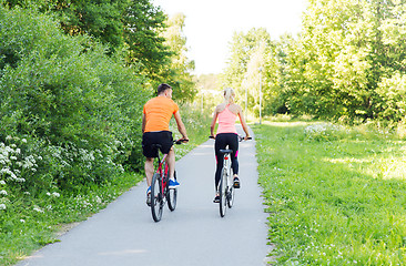 Image showing happy couple riding bicycle outdoors