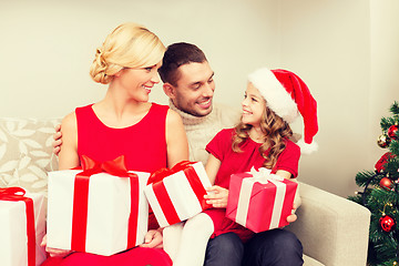 Image showing smiling family holding many gift boxes