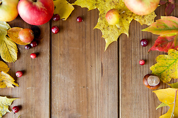 Image showing frame of autumn leaves, fruits and berries on wood