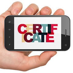 Image showing Law concept: Hand Holding Smartphone with Certificate on  display