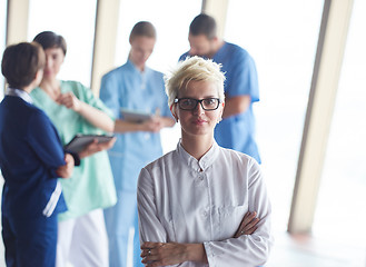 Image showing female doctor with glasses and blonde hairstyle standing in fron