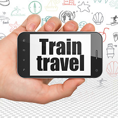 Image showing Vacation concept: Hand Holding Smartphone with Train Travel on display