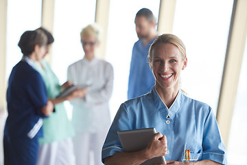 Image showing female doctor with tablet computer  standing in front of team