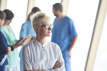 Image showing female doctor with glasses and blonde hairstyle standing in fron