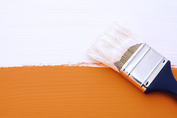 Image showing Painting orange surface with white paint