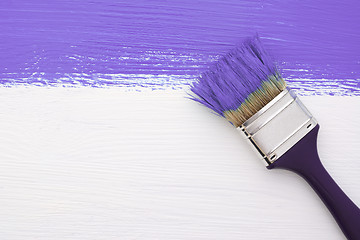 Image showing Stripe of purple paint with a paintbrush on white