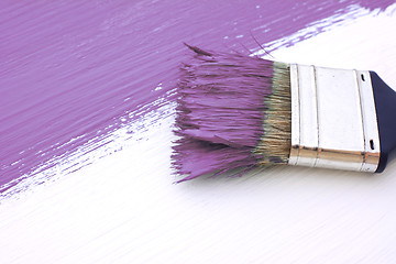 Image showing Close-up of paintbrush painting a white board purple