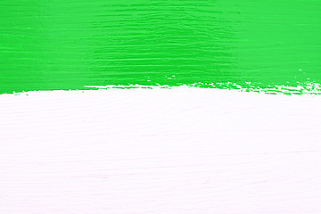 Image showing Stripe of green paint over white wooden background