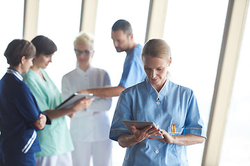 Image showing female doctor with tablet computer  standing in front of team