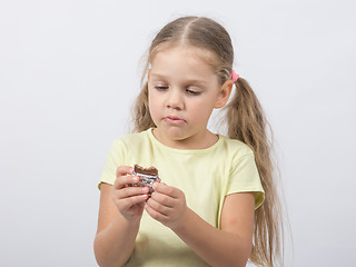 Image showing Four-year girl eats a chocolate sweet tooth