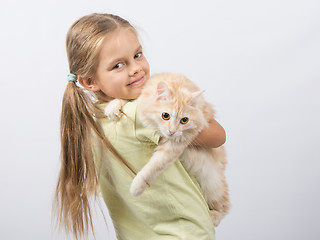 Image showing Six year old girl holding a cat in her arms